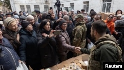 乌克兰总统泽连斯基在布查镇的一处人道主义中心与当地居民握手。(2022年4月4日)