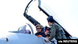 在卡姆拉空军基地举行的接装仪式上，巴基斯坦总理伊姆兰·汗坐在中国制造的歼-10C战斗机的驾驶舱内，听取介绍。(2022年3月11日)