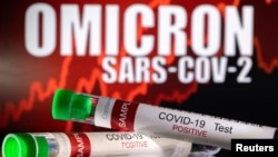 資料照：奧密克戎的字樣前擺放著“新冠測試陽性”的試管圖像 （2021年12月11日）