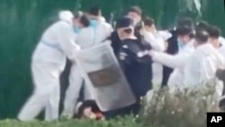 據目擊者和社交媒體上的視頻稱，鄭州全球最大的蘋果手機工廠的員工在反病毒控制和工資抗糾紛的議活動中遭到毆打和拘留。 (美聯社照片）