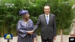 2022年12月8號，中國總理李克強和世界貿易組織總幹事恩戈齊·奧孔喬-伊維拉在中國安徽黃山舉行會談前握手拍照。隨著中調整其新冠對抗政策，中國有信心使經濟恢復持續發展。照片發自中國中央電視台，由美聯社提供。