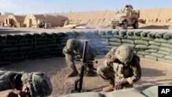 ແຟ້ມພາບ - ທະຫານກອງທັບບົກສະຫະລັດດຳເນີນການຊ້ອມຍິງປືນຄົກ ຢູ່ປ້ອມທະຫານພັນທະມິດນ້ອຍ ຢູ່ໃນພາກຕາເວັນຕົກຂອງອີຣັກ ໃກ້ຊາຍແດນຕິດກັບຊີເຣຍ, ວັນທີ 24 ມັງກອນ 2018. 