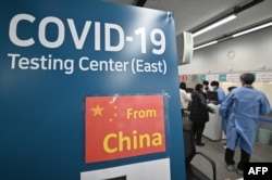 韩国仁川国际机场的医护人员为从中国抵达的乘客进行核酸检测。（2023年1月3日）