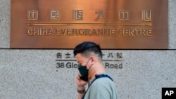 资料照 - 一名路人走过中国恒大香港总部大楼。美联社照片。2021年10月4日。