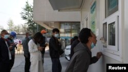 在北京與河北省的交界附近的新冠病毒檢測站，一位男子張開嘴接受檢測。(2022年4月20日)