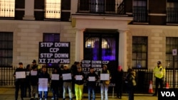 示威者拿着抗議標語牌在中國駐英大使館外示威。(美國之音/鄭樂捷）