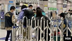 香港海關人員詳細檢查前往中國大陸旅客的48小時核酸檢測陰性證明。(美國之音/湯惠芸)