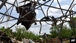 烏克蘭斯拉夫揚斯克的民眾在整理被戰火炸毀的一座建築廢墟。（2022年6月1日）