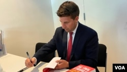 《最后的斗争：中共全球战略大揭秘》作者易思安2022年7月27日在华盛顿一场新书讨论会上为读者签名 （美国之音锺辰芳拍摄）