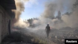 烏克蘭一名救援人員在頓涅茨克地區托列茨克鎮被俄軍炸毀的住宅區廢墟中行走。（2022年7月27 日）