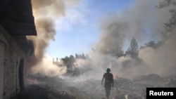 乌克兰一名救援人员在顿涅茨克地区托列茨克镇被俄军炸毁的住宅区废墟中行走。（2022年7月27 日）
