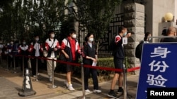 北京考生在進入高考考場前排隊等候測量體溫。 （2022年6月7日）