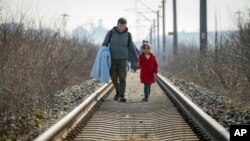在土耳其靠近希臘邊境地區火車軌上行走的人