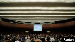 世卫组织的代表们在日内瓦联合国机构里在观看介绍阻止非洲埃博拉疫情蔓延的幻灯片。（2018年5月23日）