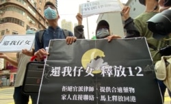 多名被關押鹽田看守所的港人家屬9月30日手持寫上4大訴求的標語，由西區警署遊行到北京駐港機構中聯辦外請願，要求釋放12港人。（美國之音湯惠芸攝）