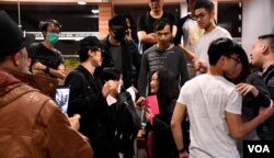 集會進行期間有懷疑親北京人士(手持粉紅手機者)在場拍攝，被集會人士包圍，由港大保安人員護送離場。(美國之音湯惠芸)