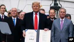 Президент США Дональд Трамп демонстрирует только что подписанное им соглашение о торговле с Канадой и Мексикой. 29 января 2020 года