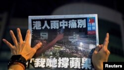 一名苹果日报的支持者手拿最后一期的苹果日报（路透社2021年6月24日）