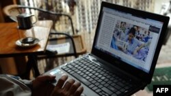 一名男子在河内市中心的一个咖啡馆用他的笔记本电脑阅读网上新闻（资料图片）