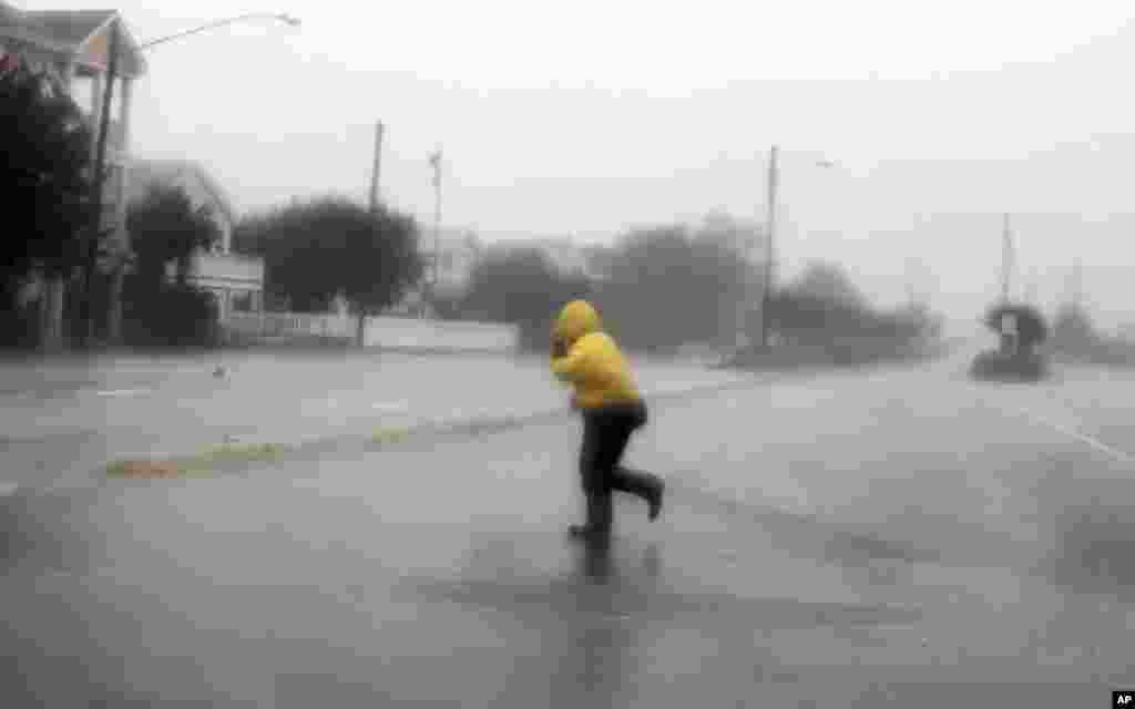 A pedestrian crosses an open area as Hurricane Irene passes through Wrightsville Beach, North Carolina, August 27, 2011. Hurricane Irene howled ashore in North Carolina with heavy winds, rain and surf on a path threatening the densely populated U.S. East 