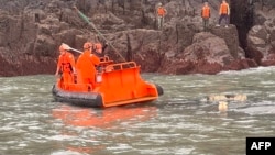 資料照片: 2024年3月14日台灣海警隊成員(橘色頭盔)與中國海警隊參與聯合搜救中國傾覆漁船