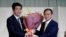 日本首相安倍晋三为在自民党总裁选举中获胜的日本官房长官菅义伟献花。（2020年9月14日）