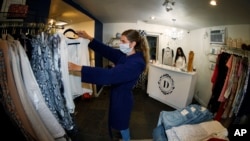 5月9日，科罗拉多州丹佛市准许商店重新开门营业。店员斯塔克整理商品，店主莫利在柜台忙碌。