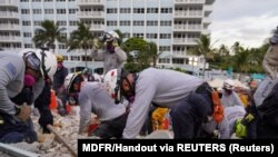 搜救队员6月29日在佛罗里达瑟夫塞德（Surfside）一座部分坍塌的公寓楼现场搜寻。（路透社照片）