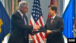 2014年10月23日，美國國防長哈格爾與韓國防長韓民求（右）在五角大樓簽署諒解備忘錄後握手。 