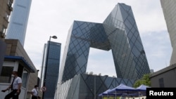 人們在北京的央視大樓旁排隊等候進行新冠核酸檢測。 （2022年5月18日）