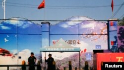 Охранники у ворот того, что официально известно как центр профессионального обучения в округе Хуочэн в Синьцзяне, Уйгурском автономном районе Китая