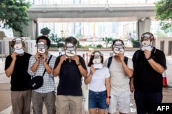 支持民主的香港跨工會聯盟的支持者2021年7月23日在西九龍法院外戴上羊面具抗議。該工會成員現在因“羊村”系列兒童繪本被警方國安處人員拘捕，指控他們涉嫌“串謀刊印、發佈、分發、展示或複製煽動刊物”罪。