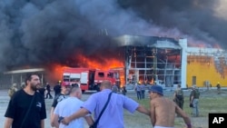 烏克蘭克列門丘格市一座購物中心被俄羅斯導彈擊中後起火燃燒。 (2022年6月27日)