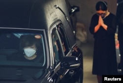 安倍晉三的遺孀昭惠坐在安邦的靈車前座開往寺廟。（2022年7月11日）