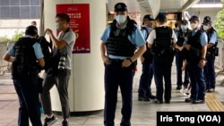 今年7月1日香港主權移交25週年，警方在灣仔一條通往會議展覽中心的行人天橋上嚴密佈防，搜查一名在場採訪的攝影記者。(美國之音 湯惠芸)