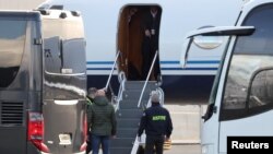 Сотрудники правоохранительных органов у самолета с Родриго Дутерте на борту после его прибытия в аэропорт Роттердама в Гааге, 12 марта 2025 года