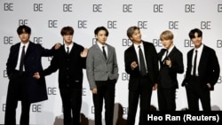 FILE PHOTO: Members of K-pop boy band BTS pose for photographs during a news conference promoting their new album "BE(Deluxe Edition)" in Seoul, South Korea.