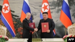 俄罗斯总统普京与朝鲜领导人金正恩在平壤举行的签字仪式上合影。（2024年6月19日）