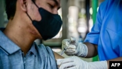 2023年12月19日，一名衛生工作者在雅加達省衛生辦公室為一名男子接種 Covid-19 疫苗。 （法新社照片）