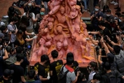 香港大學的學生在清理為悼念六四死難者而樹立的“國殤之柱”。 （2021年6月4日）