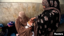 一名女性小儿麻痹症疫苗接种工作者在巴基斯坦白沙瓦的一家医院为儿童注射疫苗。（2012年12月8日）