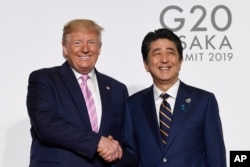 美國總統朗普與日本首相安倍在G20大阪峰會上握手。