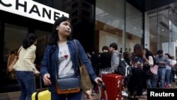 一名中國大陸遊客在名店前。（資料圖片)