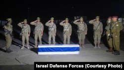 2025年11月13日，在加沙地带，以色列国防军士兵向哈马斯归还的、装有被扣押人质梅尼·戈达尔遗体的灵柩致敬。以色列国防军首席拉比埃亚尔·克里姆准将(右一)主持了简短的仪式。（照片来自以色列国防军）