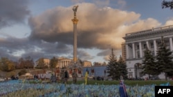 在基輔獨立廣場，穿著軍服的行人走過紀念陣亡烏克蘭軍人的旗幟。(2023年10月23日)