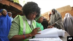 Một người đạp xe ngang qua Hợp t&aacute;c x&atilde; n&ocirc;ng nghiệp Migok ở Sariwon, tỉnh Bắc Hwanghae. Những bảng n&agrave;y ghi: &ldquo;Ra sức thu hoạch,&rdquo; (tr&aacute;i,) v&agrave; &ldquo;Để thể hiện l&ograve;ng y&ecirc;u nước do Kim Jong-Il l&atilde;nh đạo.&rdquo;<br />
