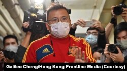 港媒《立場新聞》副採訪主任陳朗昇在離開辦公室時向香港媒體招手。 （2021年12月29日）