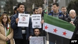 2016年1月29日,敘利亞和談開幕的當天，示威者手舉“停止在敘利亞殺戮”的標語在聯合國駐日內瓦大樓外舉行抗議。 