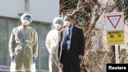 日本衛生官員戴著防疫口罩在東京的國立國際醫療研究中心等候從武漢撤回國的日本僑民。（2020年1月30日） 