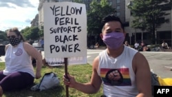 一名亞裔美國人手舉“黑人的命也是命”的標語牌